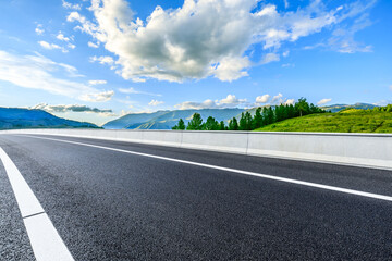 Asphalt highway road and green trees with mountain nature landscape in summer
