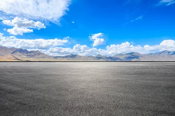 Deurstickers Asphalt road square and mountains with sky clouds on a sunny day © ABCDstock