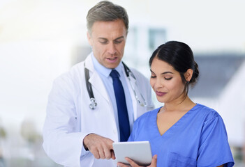 Hospital, consulting and doctor with nurse on tablet for medical service, help and diagnosis results. Healthcare, clinic and man and woman talk with digital tech for research, planning and telehealth