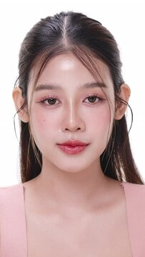 Vertical footage beautiful young Asian woman with healthy facial skin opening eyes isolated over white background for skincare commercial product advertising. Slow motion shot.