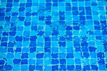 Round droplets of water over circles on pool water. Fresh water drop, whirl and splash.4