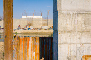 Detail of huge pole in foundation with metal piles, construction of concrete-reinforced bridge...