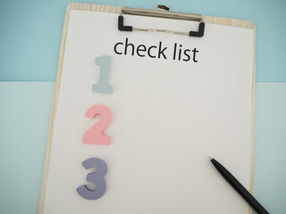 紙にcheck listチェックリストの文字と123の数字、コピースペース
