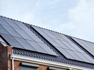 Newly built houses with black solar panels on the roof, Close up of new family home with black...