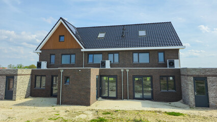 air source heat pump unit installed outdoors at a modern home with bricks in the Netherlands,...