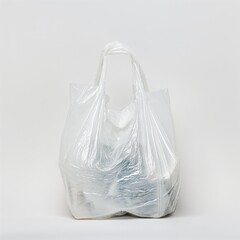 A solitary plastic carrier bag filled with contents, standing against a stark white background.
