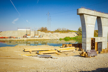 Huge pole in foundation with metal piles, construction of concrete-reinforced bridge pillars at building site