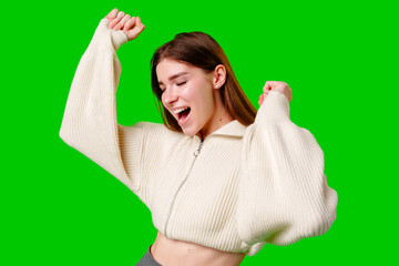 Joyful Young Woman Celebrates With Arms Raised Against Green Screen
