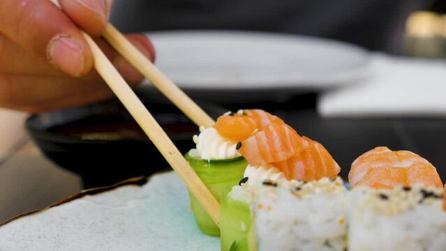 Eating sushi at a restaurant with chopsticks