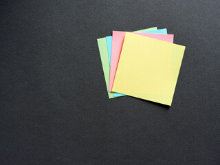 Blank or empty colorful adhesive note papers on black background.