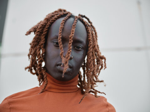 Portrait of a South Sudanese man wearing orange turtleneck