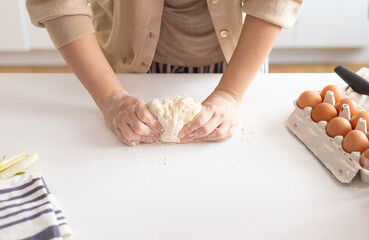 Woman preparing dumplings in kitchen at home