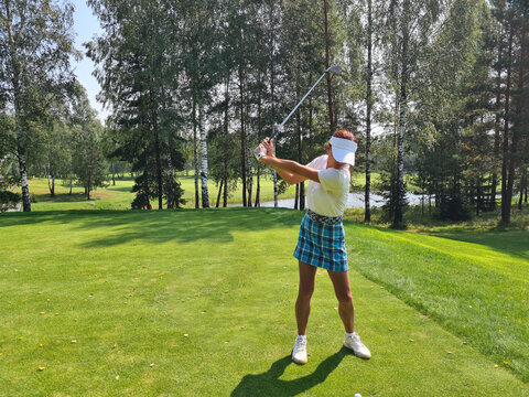 Woman Swinging Golf Club on Golf Course