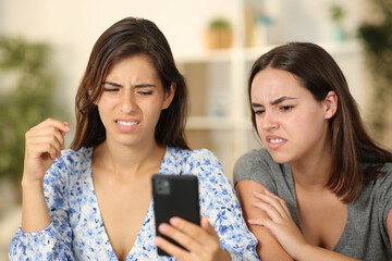Two friends watching nasty content on phone - obrazy, fototapety, plakaty
