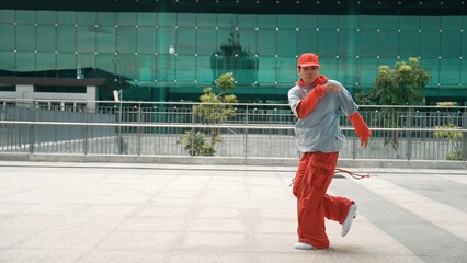 Skilled dancer moving energetic footstep while perform street dance. Professional hipster wearing...