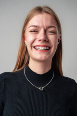 Smiling Woman in Black Top against gray background