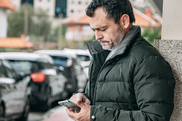 mature man using mobile phone on the street