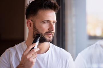 Man using electric razor and shaving his face - 785042356