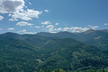 Naklejka premium Beautiful mountain landscape with green trees under blue sky on sunny day. Drone photography