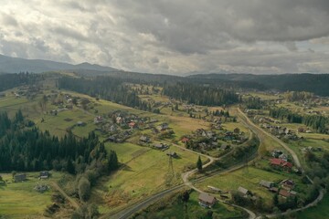 Fototapeta na wymiar Aerial view of beautiful forest and mountain village on autumn day