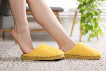 Woman in yellow soft slippers at home, closeup