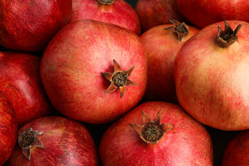 Many fresh ripe pomegranates as background, closeup