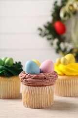 Obraz na płótnie Canvas Tasty decorated Easter cupcakes on wooden table, closeup