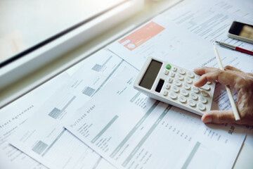 Close-up shot. business owner use calculator to manage financial documents bills invoices pay...
