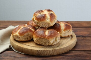 Tasty hot cross buns on wooden table