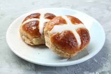 Tasty hot cross buns on gray textured table, closeup