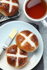 Tasty hot cross buns served on gray table, flat lay