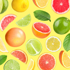 Many different fresh citrus fruits in air on light yellow background