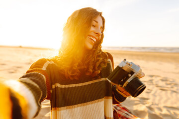 Selfie time. Young woman posing by the sea at sunset. Travel blog. Adventure, vacation concept.