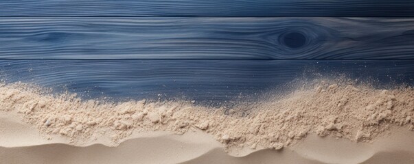 Beach sand and navy blue wooden background with copy space for summer vacation concept, text on the right side
