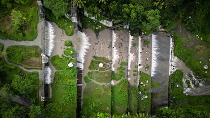 Grojogan Watu Purbo, Yogyakarta. Large multi-level dam on a river whose water is murky brownish due...