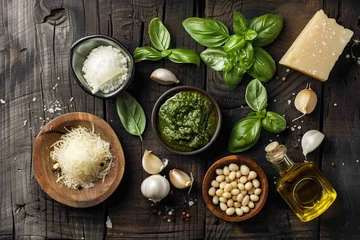 Fotobehang The ingredients for homemade pesto sauce basil, parmesan cheese ,garlic, olive oil , pine nut ,peppercorn and himalayan salt on shabby wooden background with flat lay © Barra Fire