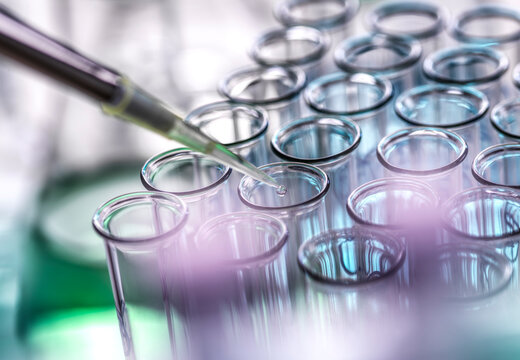 Scientist pipetting sample in test tubes at lab