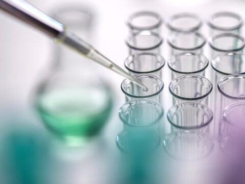 Pipette dropping sample of medicine in test tubes at lab