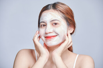 Spa girl applying facial mask. Beauty treatments mask with collagen, hyaluronic acid for glowing...