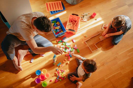 Children playing leisure games with father at home