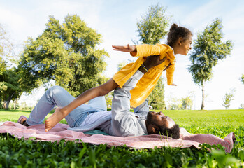 Beautiful happy african american family bonding at the park - Playful black father playing with his...