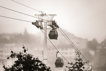 Two gondolas of the Vilanova de Gaia cable car suspended on hanging steel cables descending and...