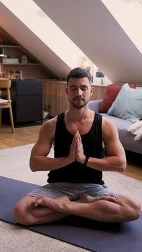 Man sits on yoga mat in living room, muscles building on comfort of flooring