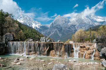 Nature view waterfall at Baishuhe River or blue moon valley and Jade Dragon Snow Mountain view with clear sky background in morning, Shangri-La or Xiang Ge Le La, Lijiang at Yunnan, China