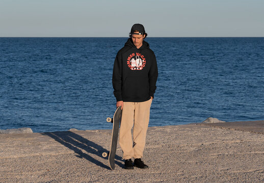 Mockup of skater wearing customized hoodie by sea