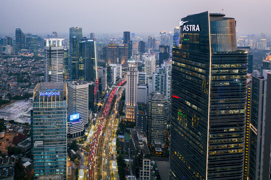 Jakarta, Indonesia - July 16 2023: Aerial view of the modern Astra tower that overlooks on the crowded Sudirman street, the main avenue in Jakarta business district at dusk