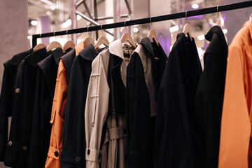 Fototapeta na wymiar Black orange fashion cloth hanging on a hangers in a row. Modern clothing collection