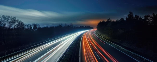 Foto op Canvas A long exposure shot of a busy highway at night showing vibrant light trails from the fast-moving cars, depicting the bustle of modern life. © Daniela