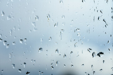Glass with rain drops against gray background. 1