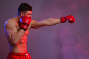 Man in boxing gloves fighting on color background. Space for text